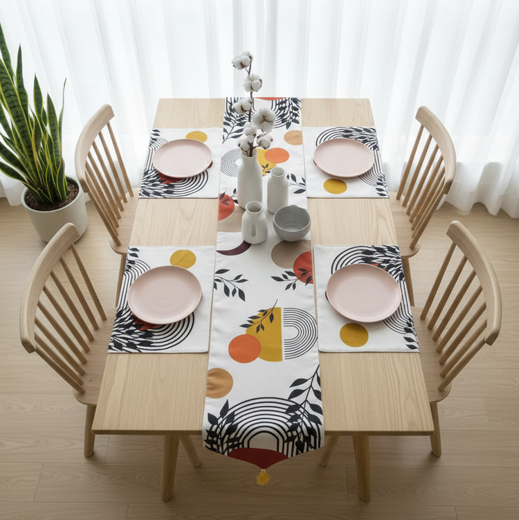 Cream table runner with abstract arches, yellow shapes and botanical motifs, with matching mats.