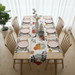Cream table runner with abstract arches, yellow shapes and botanical motifs, with matching mats.
