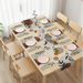 Cream table runner with brown and black botanical silhouettes and matching placemats.
