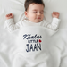 Infant under a white waffle-textured blanket with Khalas Little Jaan lettering and a red heart