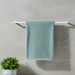 Pale turquoise bath towel draped over a towel rail.