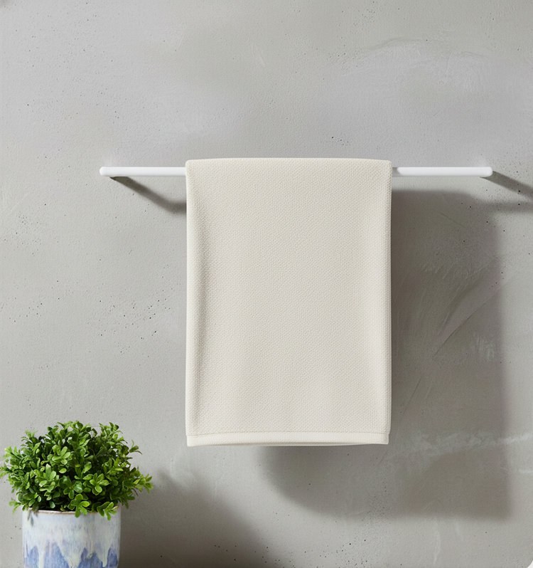 Cream bath towel draped over a towel rail.