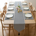 Narrow black and white striped table runner with matching placemats.