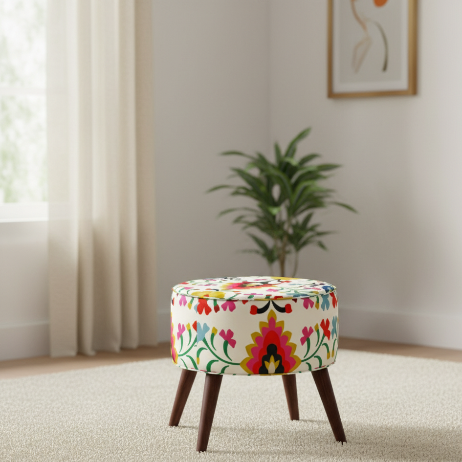 Colourful floral round ottoman beside a window in a neutral living room.