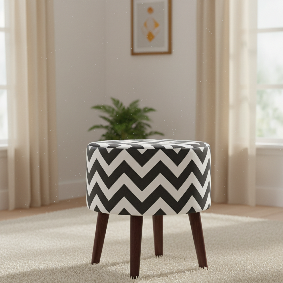 Round upholstered ottoman with a black and white chevron pattern and tapered dark legs.