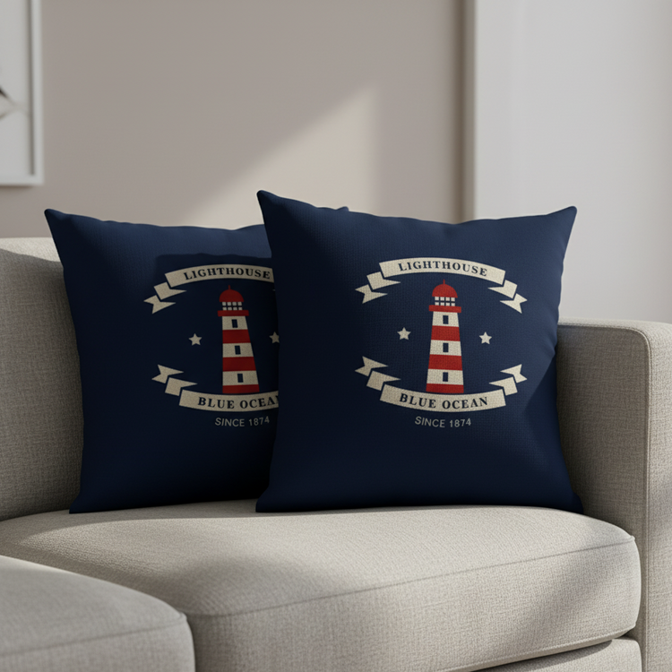 Two navy cushion covers with lighthouse illustrations and cream lettering on a chair.