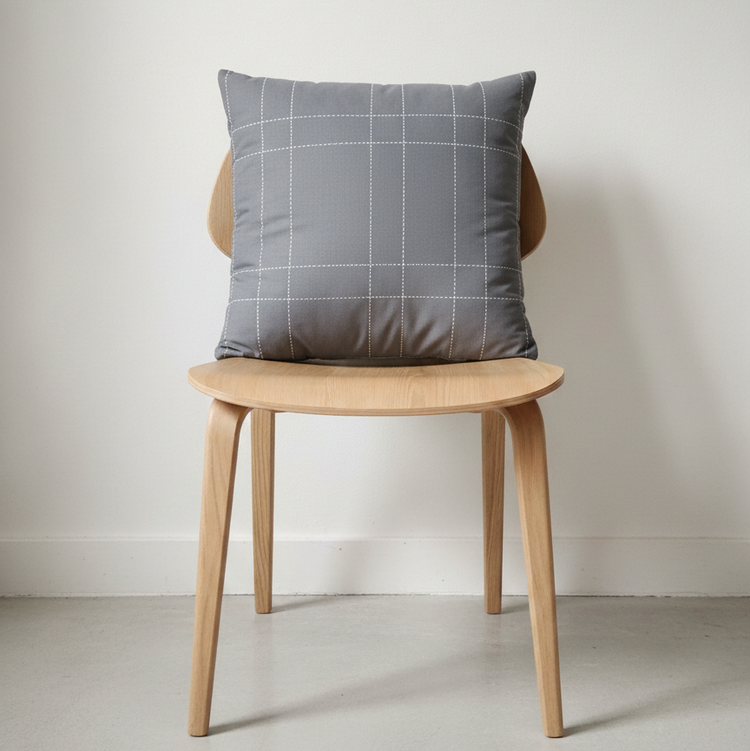 Grey cushion with a fine white windowpane check displayed on a wooden chair.