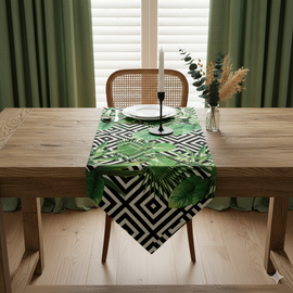 Green tropical-leaf table runner over a black and white geometric pattern.