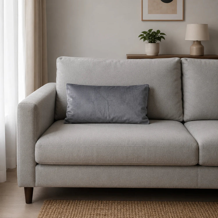 Plain rectangular silver grey filled cushion on a pale sofa.