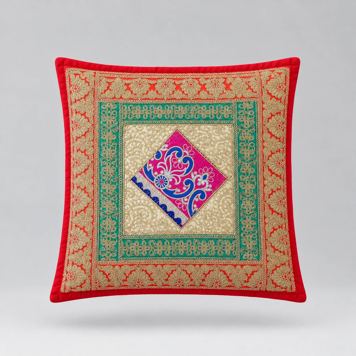 Red-bordered cushion cover with green ornamental borders and a pink and blue central diamond.