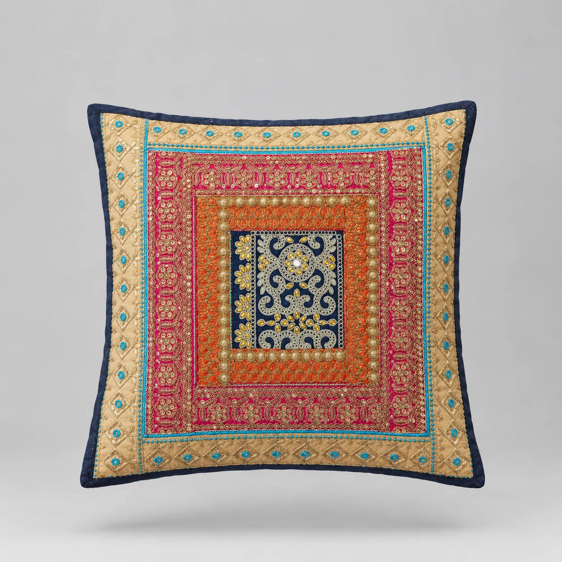 Navy-bordered cushion cover with layered turquoise, coral and gold coloured ornamental borders.