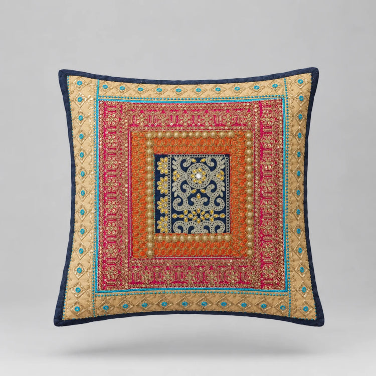 Navy-bordered cushion cover with layered turquoise, coral and gold coloured ornamental borders.