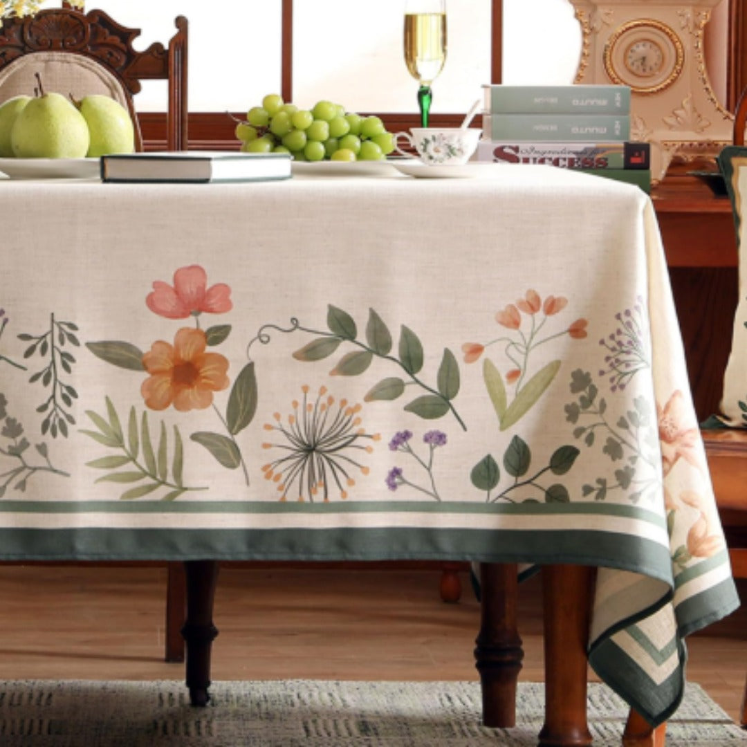 Cream tablecloth with scattered flowers and a wide green border.