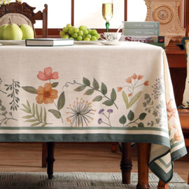 Cream tablecloth with scattered flowers and a wide green border.