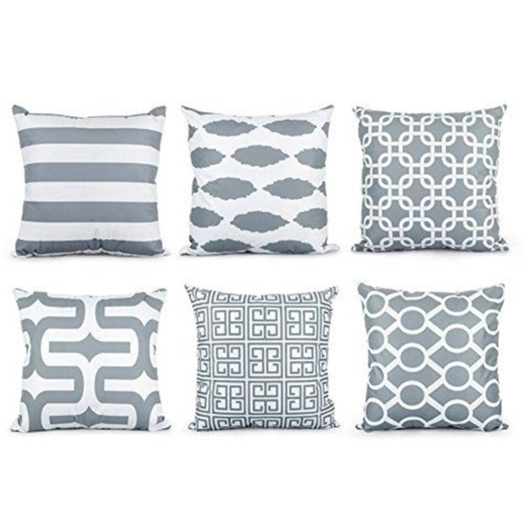 Six grey and white cushion covers with stripes and interlocking geometric patterns.