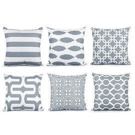 Six grey and white cushion covers with stripes and interlocking geometric patterns.