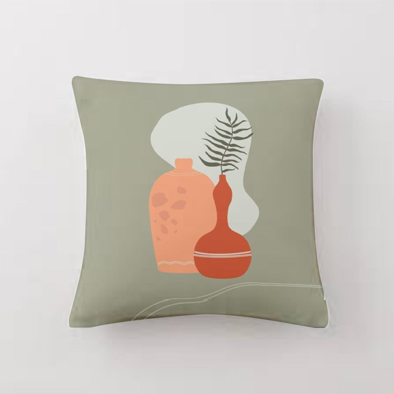 Sage green cushion cover with terracotta pots and a dark leafy sprig.