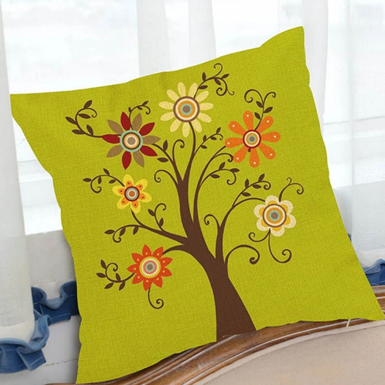 Green cushion cover with a brown tree and colourful flower-like leaves.