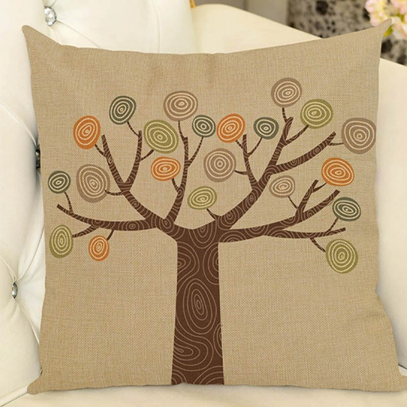 Cream cushion cover with a brown tree and circular green and orange leaves.