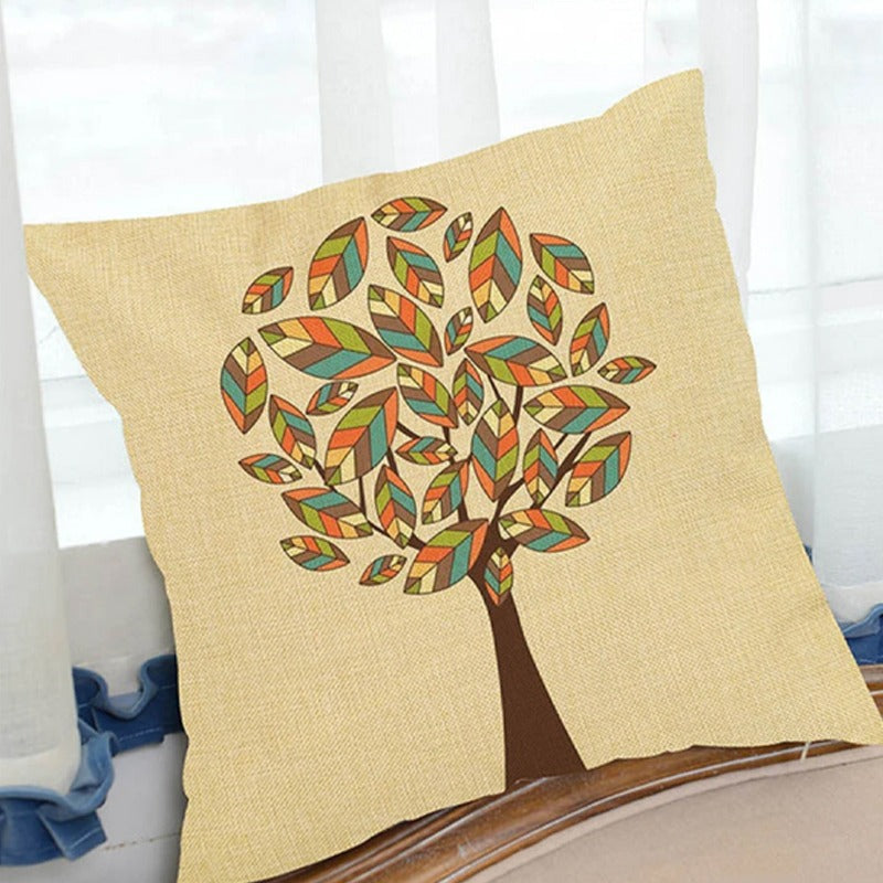 Cream cushion cover with a tree made of small multicoloured leaves.