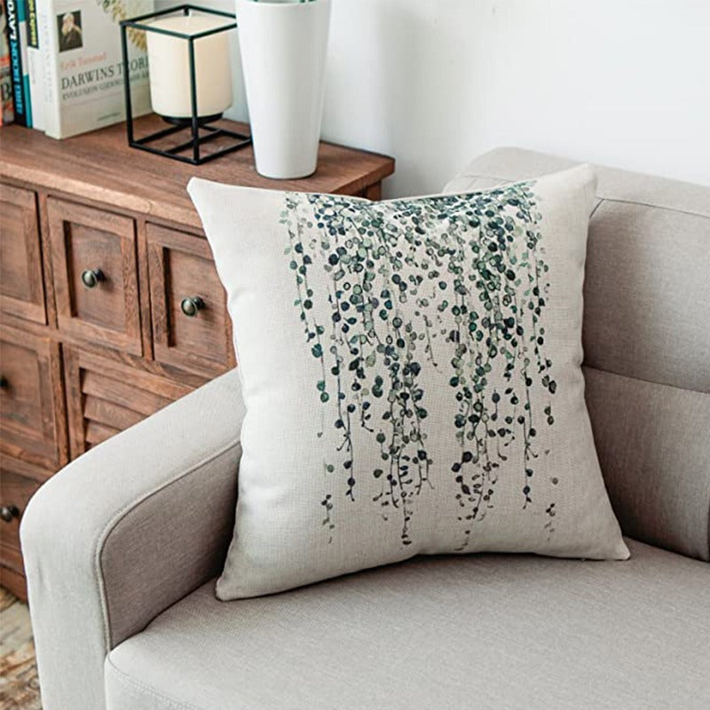 Cream cushion cover with delicate trailing green foliage.
