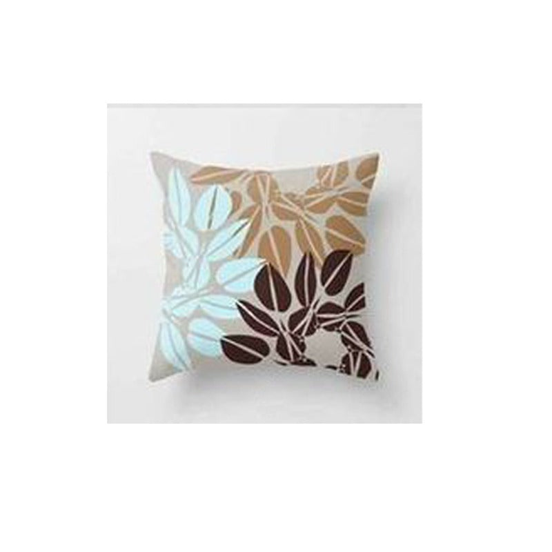 Cushion cover with overlapping pale blue, tan and brown leaf outlines.