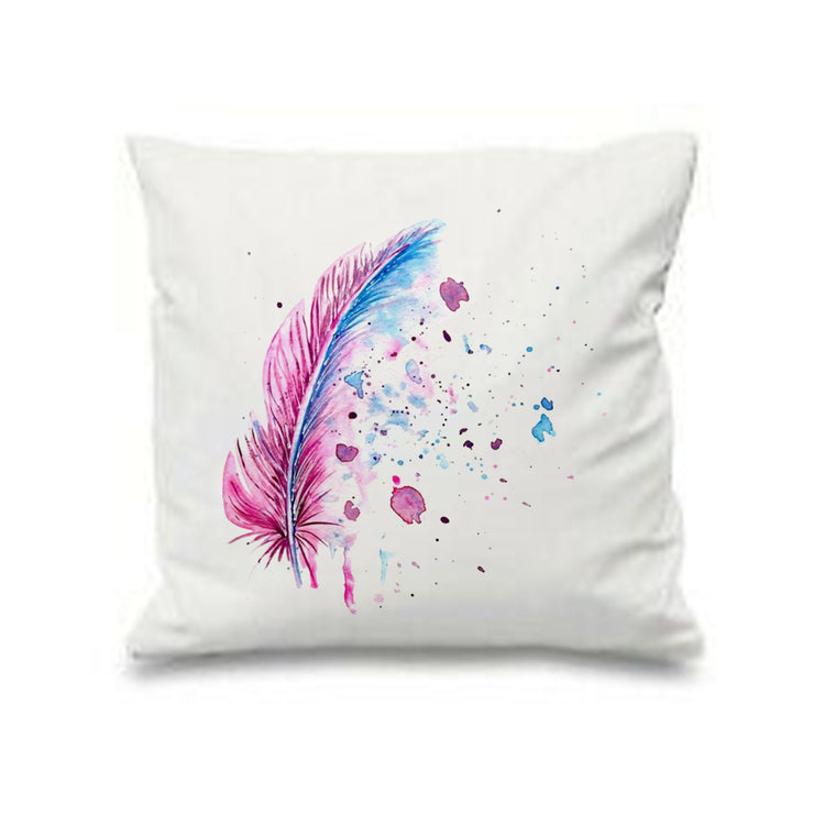 White cushion cover with a pink and blue feather and scattered paint-like speckles.