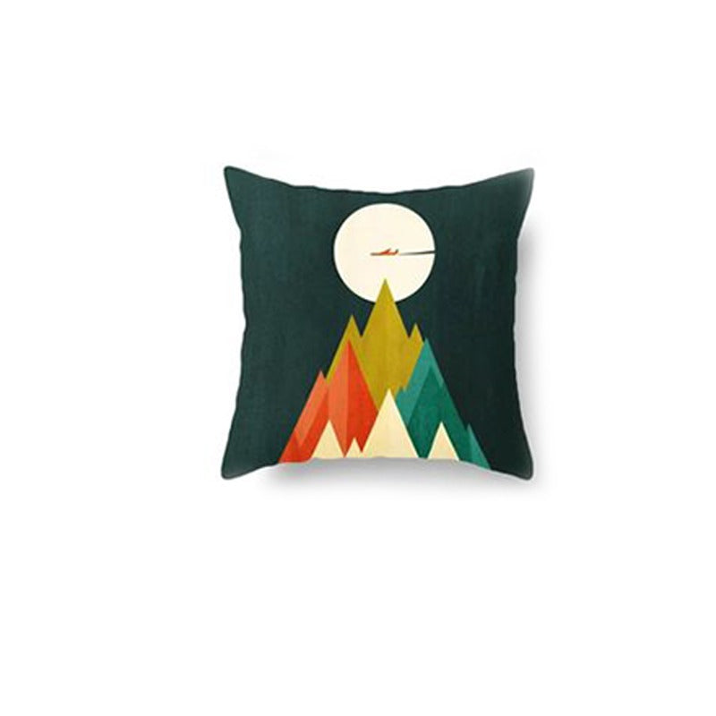 Dark green cushion cover with colourful pointed mountains and a pale moon.