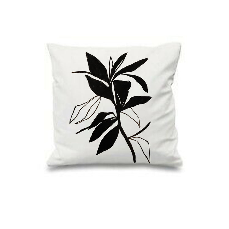 White cushion cover with bold black leaves and delicate leaf outlines.