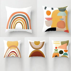 Five cream cushion covers with muted rainbow and abstract geometric prints.