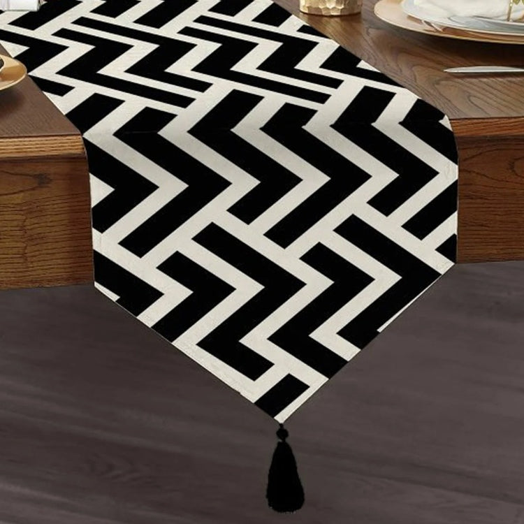 Black and white zigzag table runner with a tasselled end.