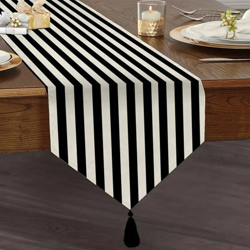 Table runner with narrow black and white stripes and a tasselled end.