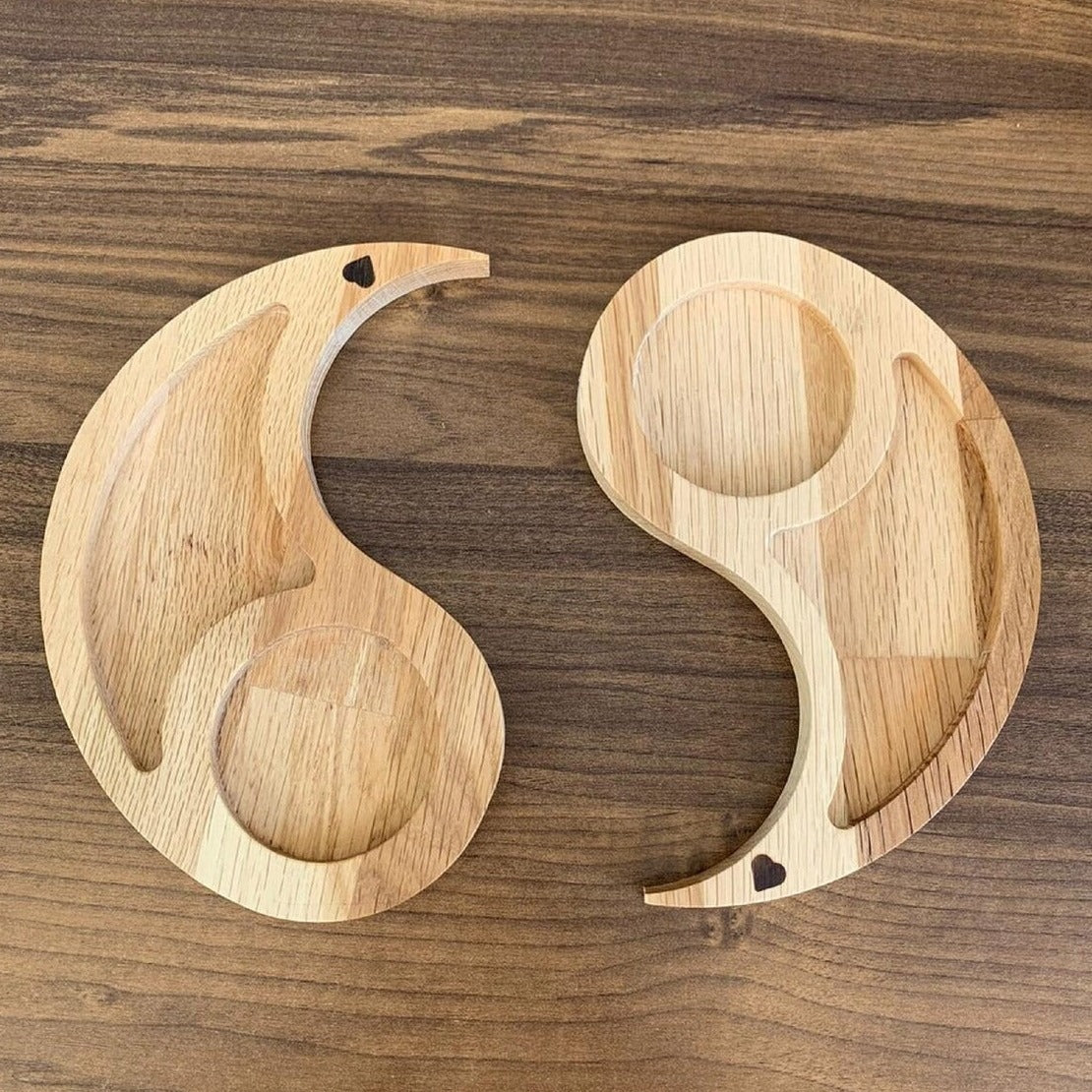 Two separated curved wood-tone trays with circular cup recesses