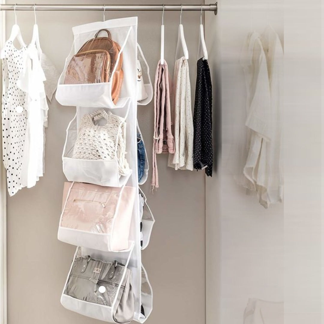 White hanging handbag organizer holding several bags beside a clothing rail.