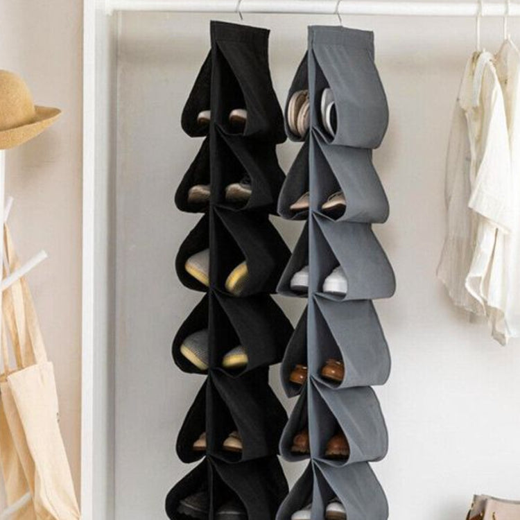 Black and grey hanging shoe organizers filled with shoes in a wardrobe.