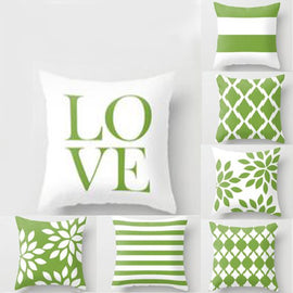 Green and white cushion covers with LOVE lettering, stripes and geometric leaf patterns.
