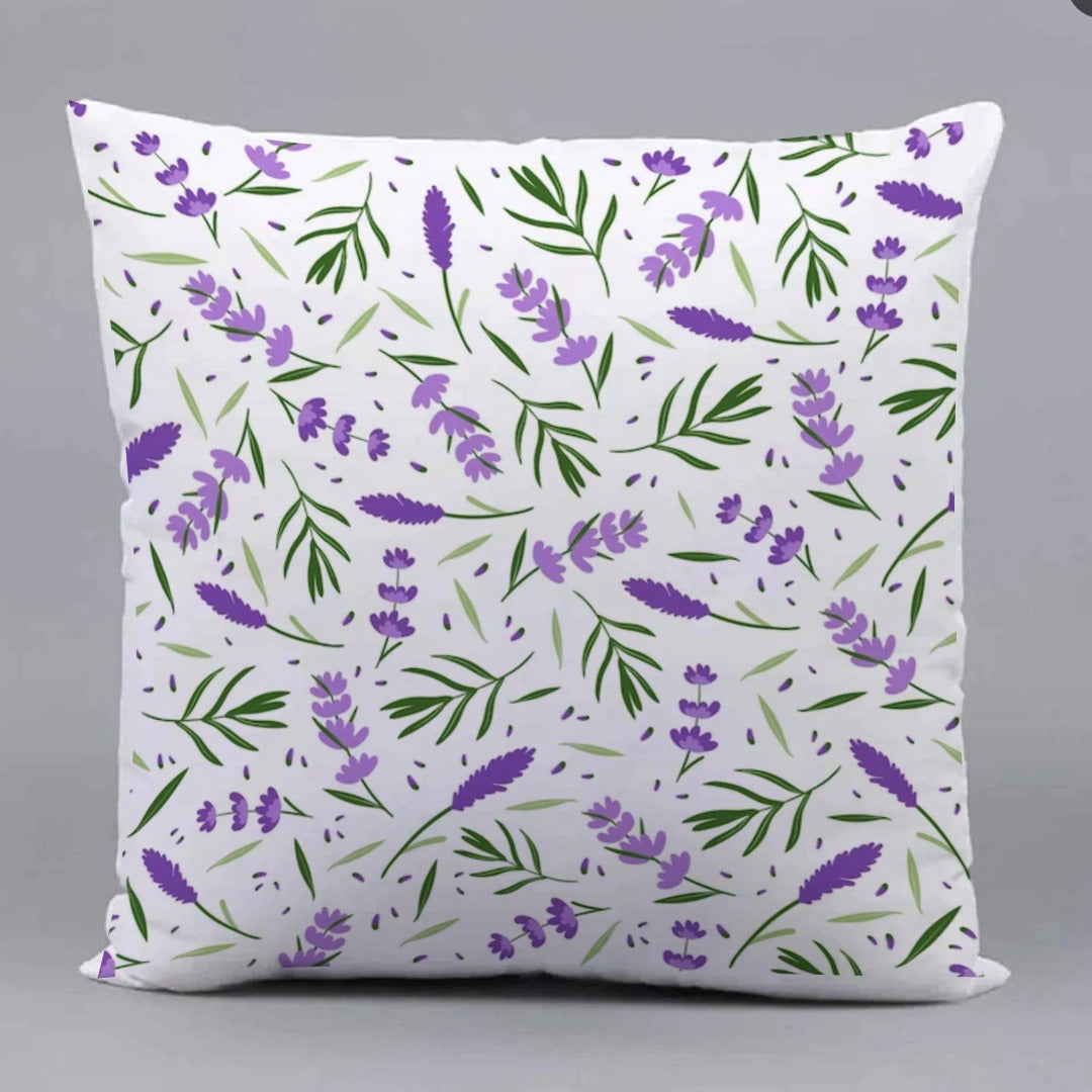 White cushion cover with a repeating purple flower and green leaf pattern.