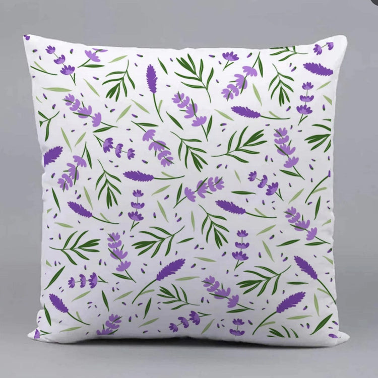 White cushion cover with a repeating purple flower and green leaf pattern.