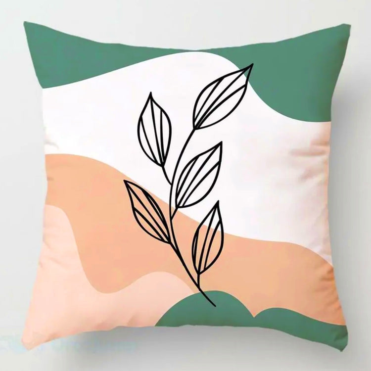 Cushion cover with a black leafy stem over peach, cream and green shapes.