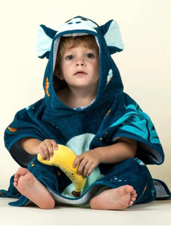 Seated child wearing a navy jungle-animal hooded towel poncho.