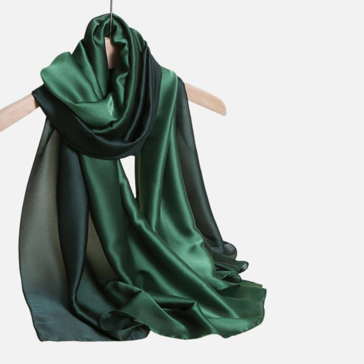 Deep green scarf draped on a wooden hanger.