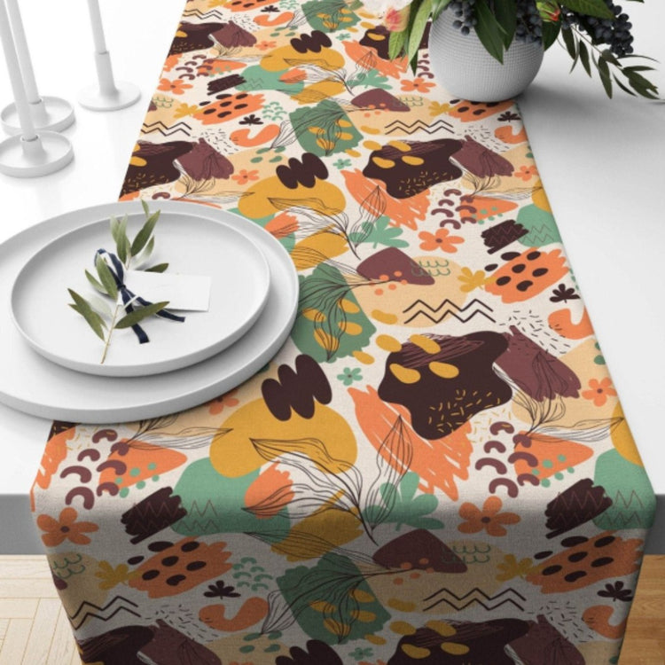 Multicoloured patchwork floral table runner beneath a white plate.