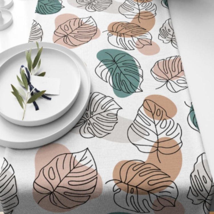 White table runner with outlined leaves and muted green and peach shapes.