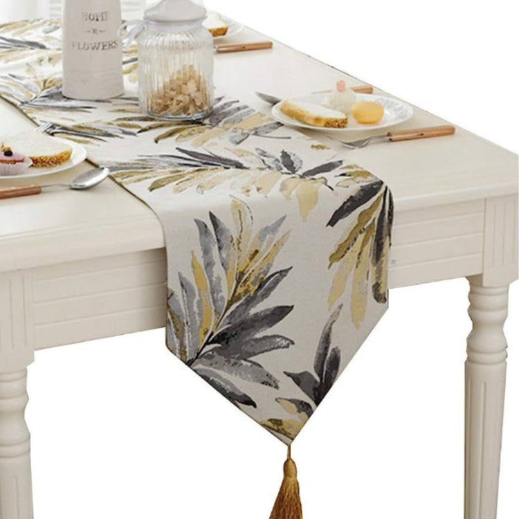 Cream table runner with grey and mustard botanical leaf prints.