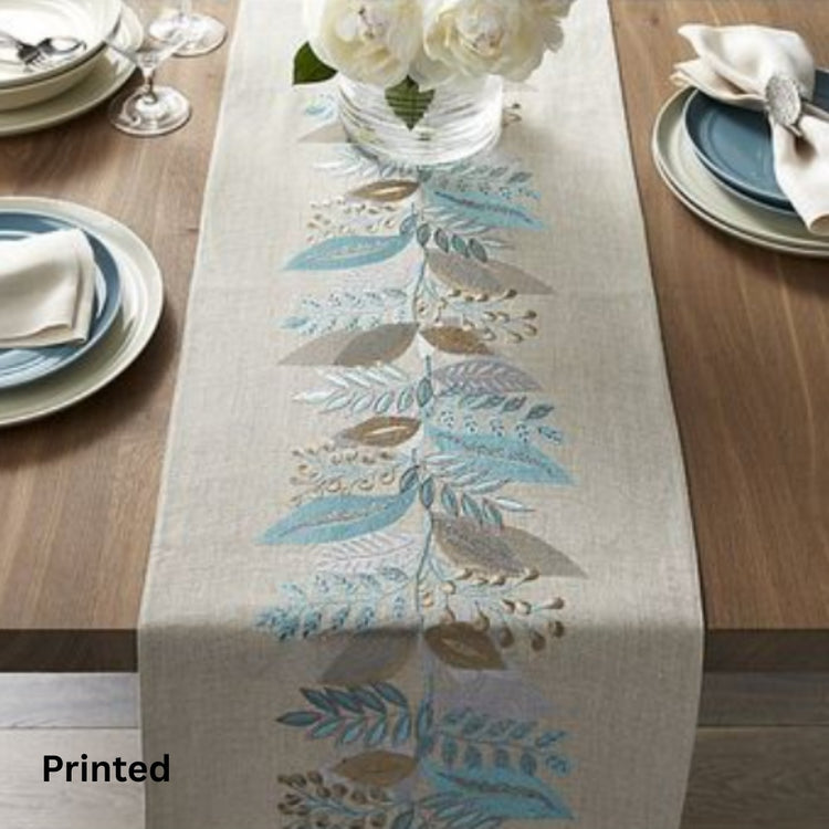 Neutral table runner with blue and brown leafy branches on a set dining table.