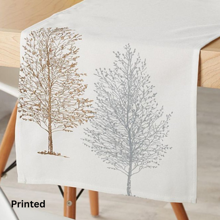 Cream table runner with delicate grey and brown tree silhouettes.