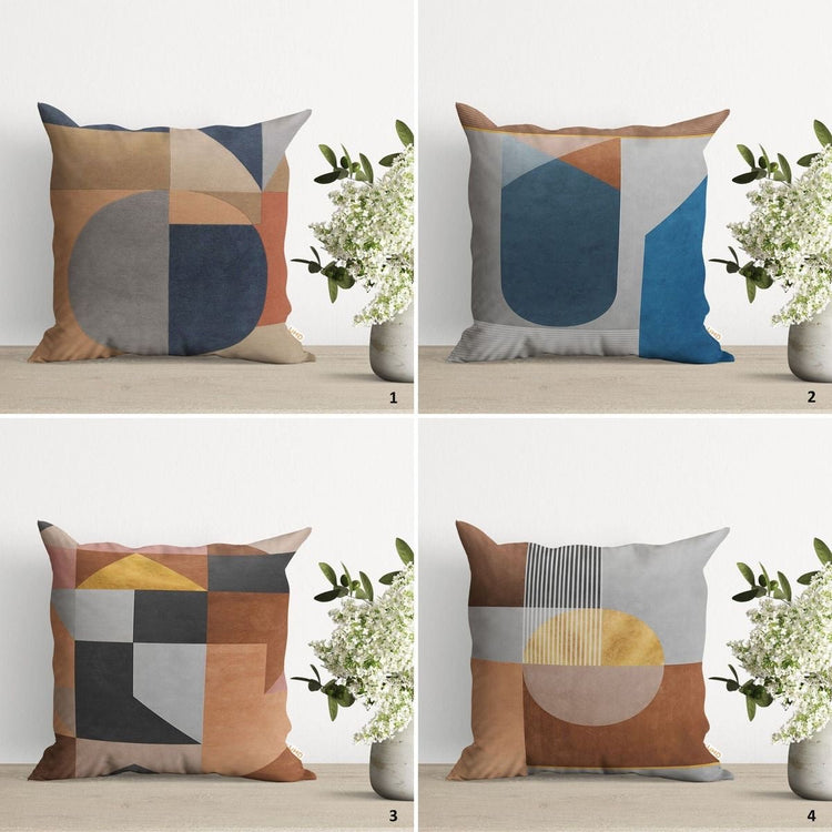 Four cushion covers with muted blue, brown, grey and ochre abstract geometric panels.