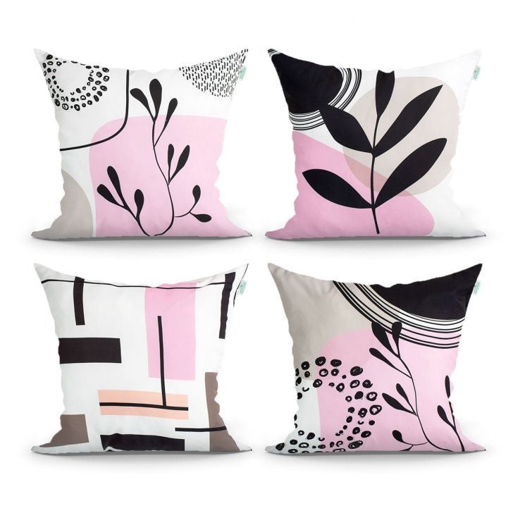 Four white cushion covers with pink panels, black leaves and abstract line details.