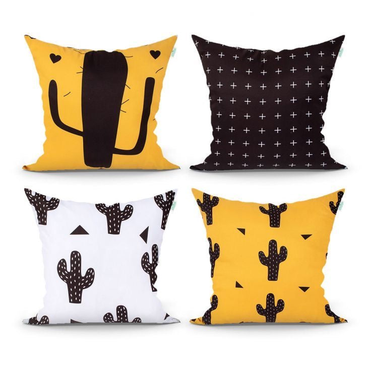Four yellow, black and white cushion covers with cactus illustrations and small cross patterns.