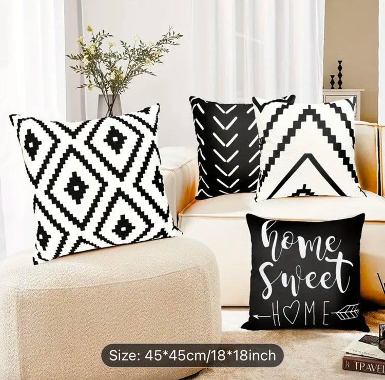 Black and cream geometric and Home Sweet Home cushion covers displayed around a chair.